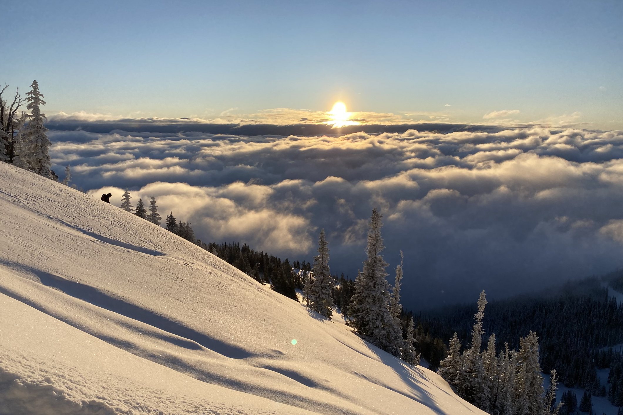 Sunrise over a sea of clouds from a snowy slope