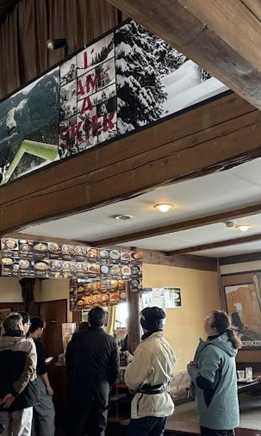 Skiers lined up at the counter under the I AM A SKIER banner, Wadagoya Lodge, Kagura