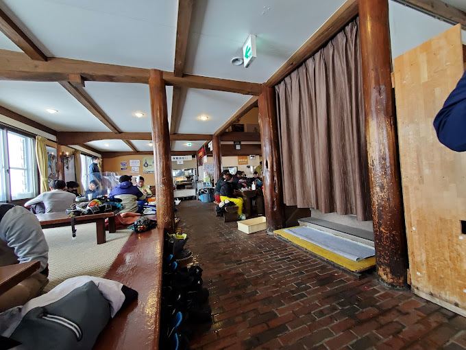 The tatami room at Wadagoya Lodge in Kagura, ski boots lined up along the step